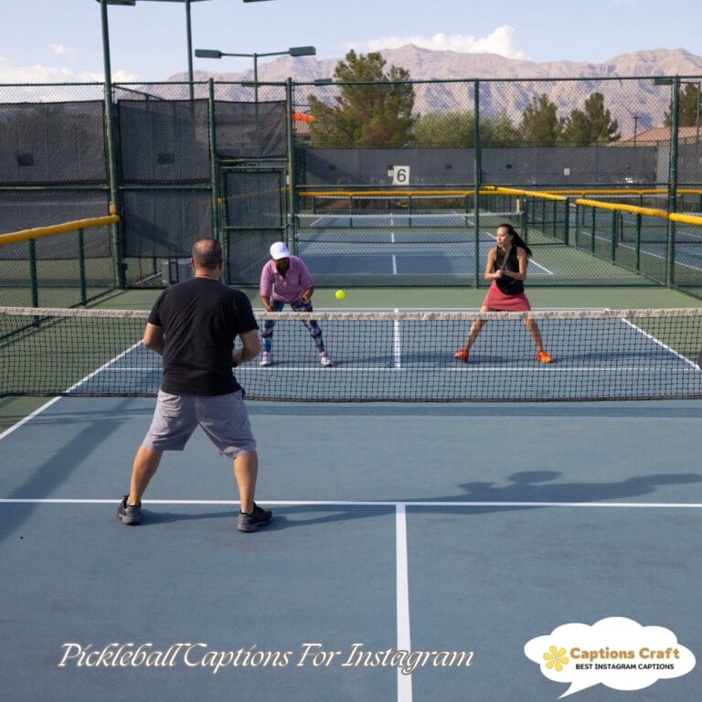 Three people playing pickleball on an outdoor court, with a scenic backdrop.