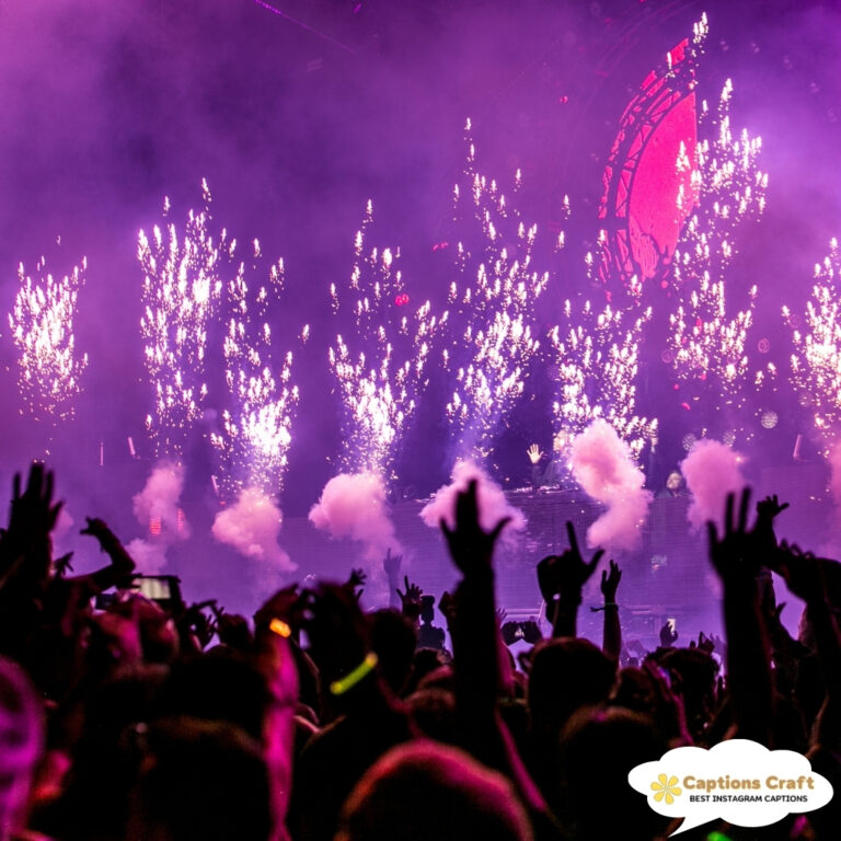 Crowd cheering at a concert with fireworks lighting up the stage.