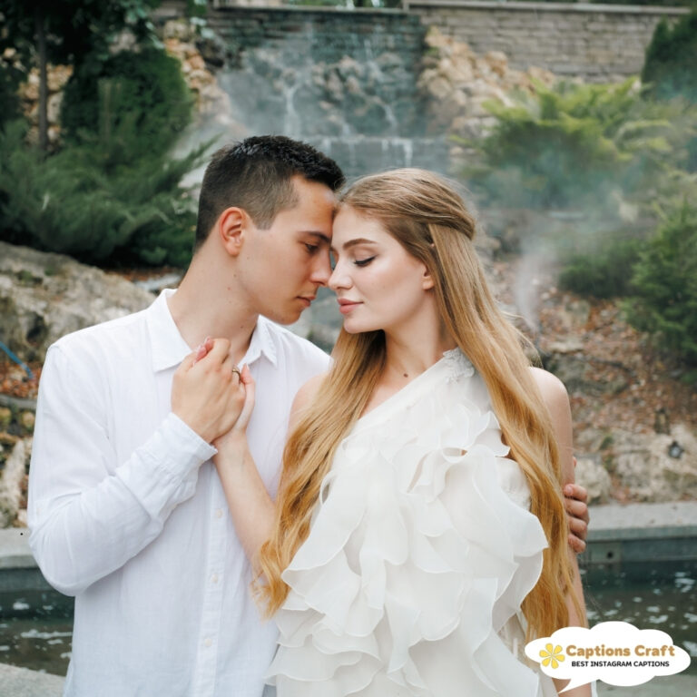 Couple leaning in for a romantic moment by a serene water feature.