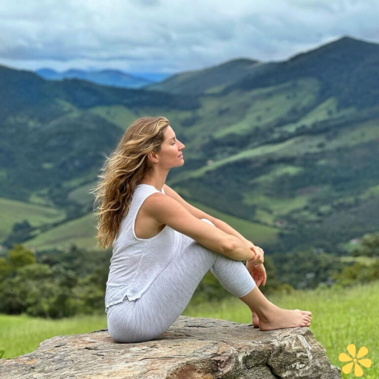 Woman meditating on a rock, serene expression, mountains in the background, lush greenery all around.