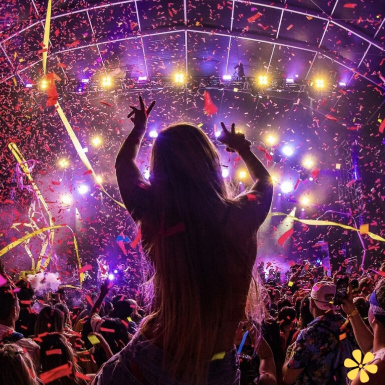 A lively concert scene with a silhouette of a woman dancing amidst colorful confetti and vibrant lights.