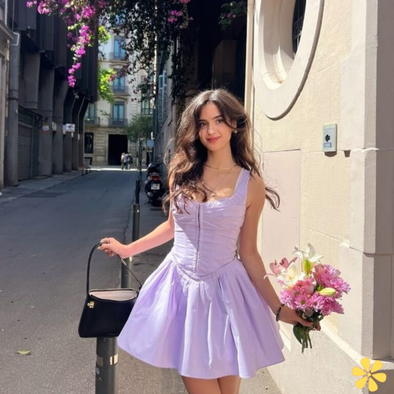Young woman in a lilac dress holding flowers in a city street