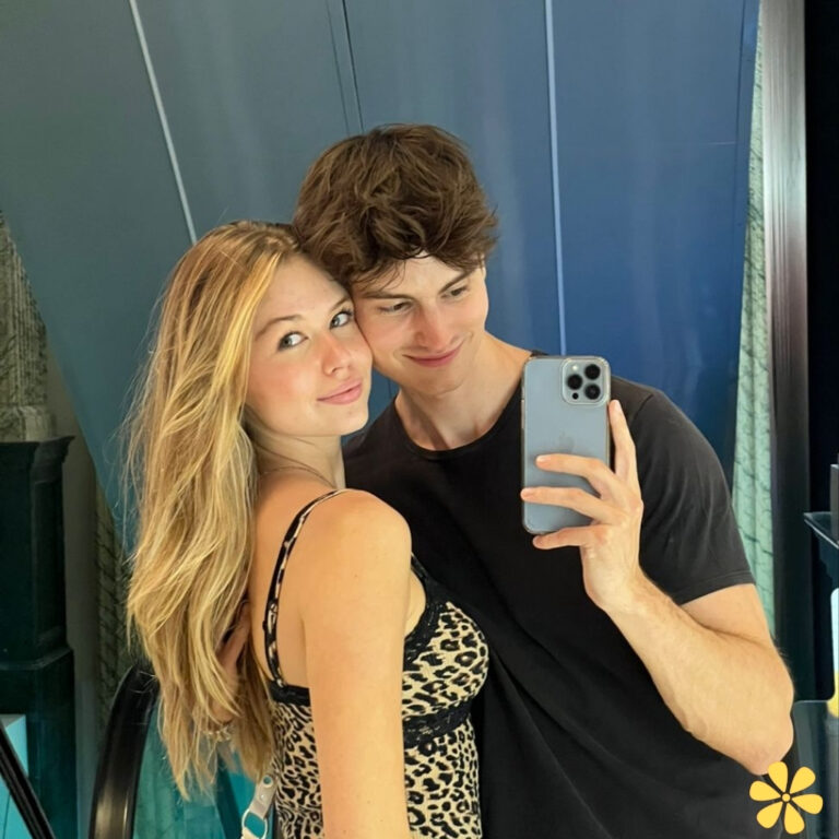 Couple smiles together, reflecting joy and affection while taking a selfie in a stylish setting.