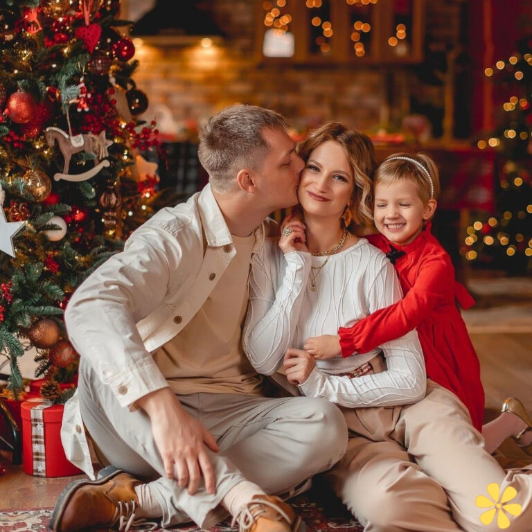 Family embracing by a decorated Christmas tree, sharing smiles and warmth.