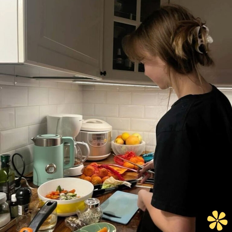 A person chopping vegetables in a cozy kitchen filled with fresh ingredients.