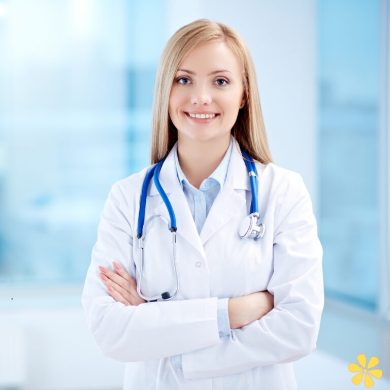 Smiling doctor in a white coat with a stethoscope, arms crossed, bright office background.