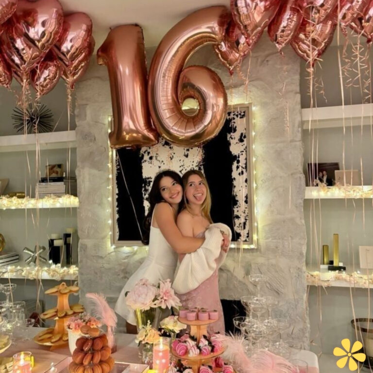 Two girls celebrating a sweet 16 birthday with pink decor and balloons.