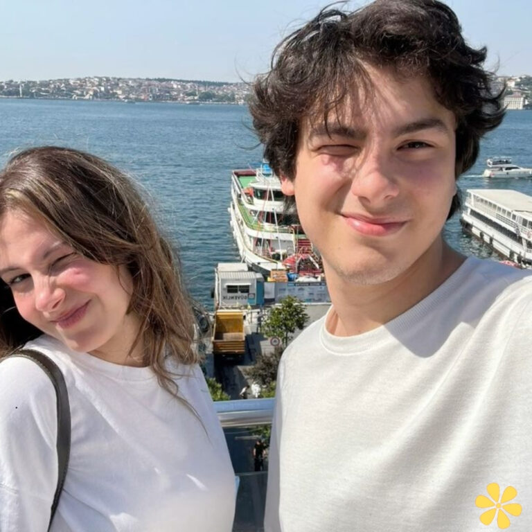 Two friends smiling and winking by the waterfront.