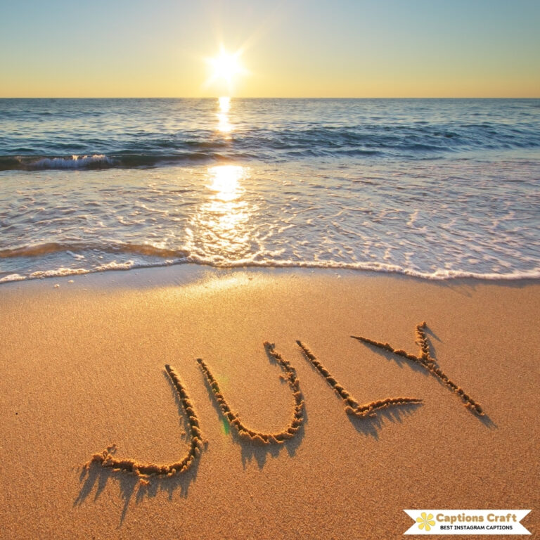 The word 'JULY' written in the sand by the shore as waves gently wash over it.